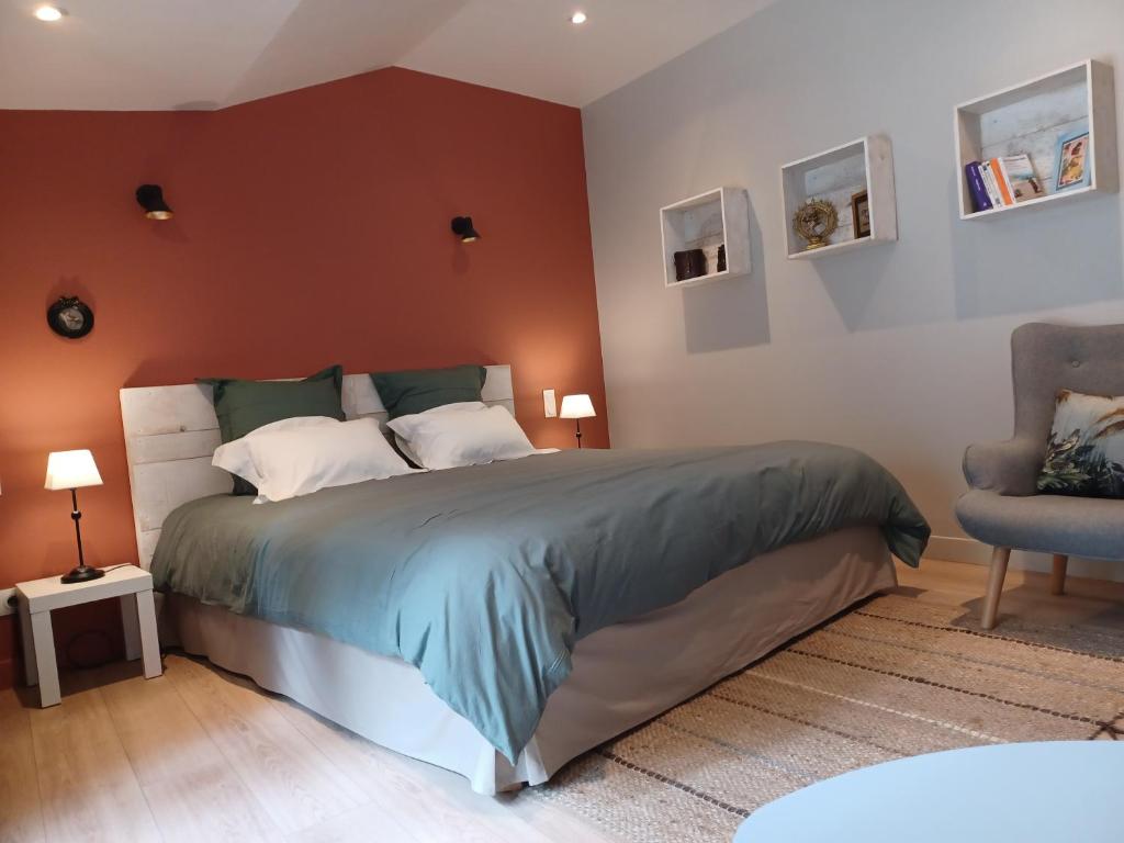 a bedroom with a large bed and a chair at Shanti Home in La Tour-sur-Orb