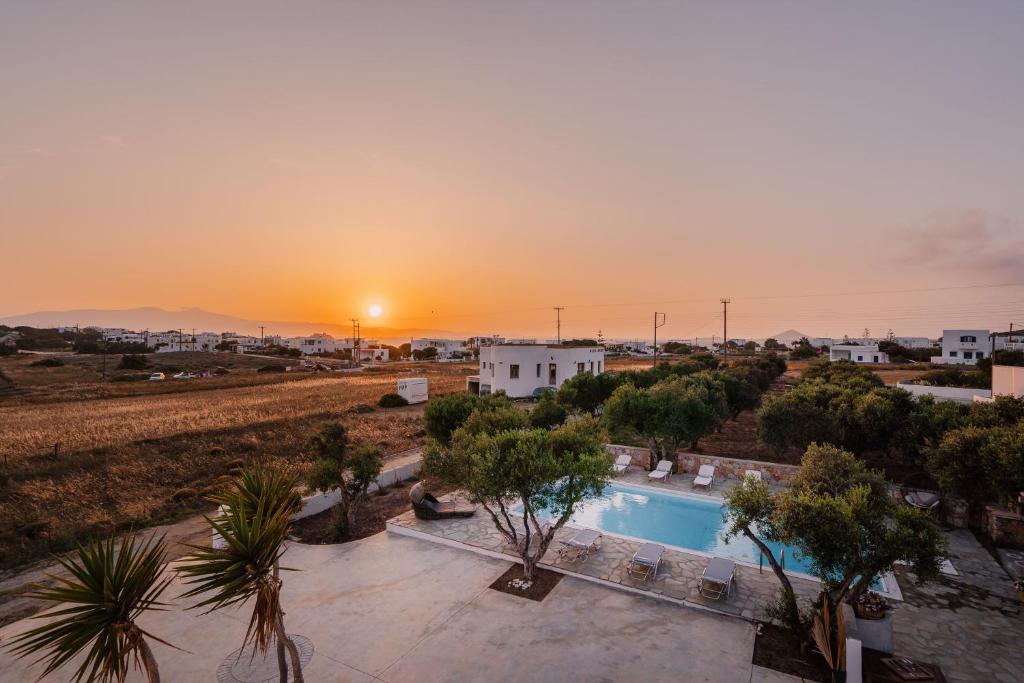 a view of a pool with a sunset in the background at Diamantis Studios&Apartments in Mikri Vigla