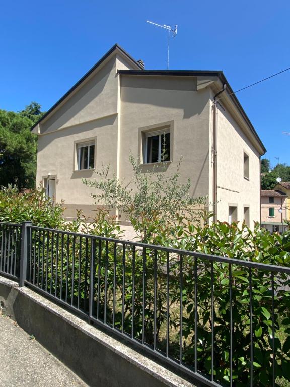 una casa bianca dietro una recinzione nera di Casa Maddalena a Casal Fiumanese