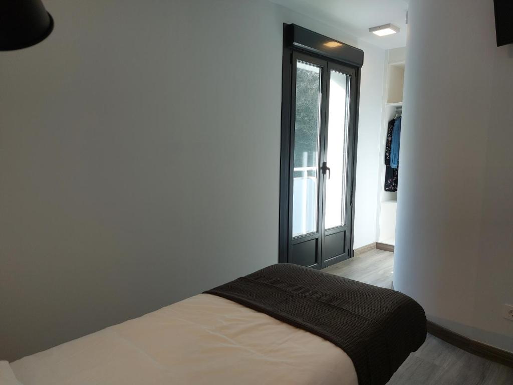 A bed or beds in a room at Pensión Amorrortu Lemona