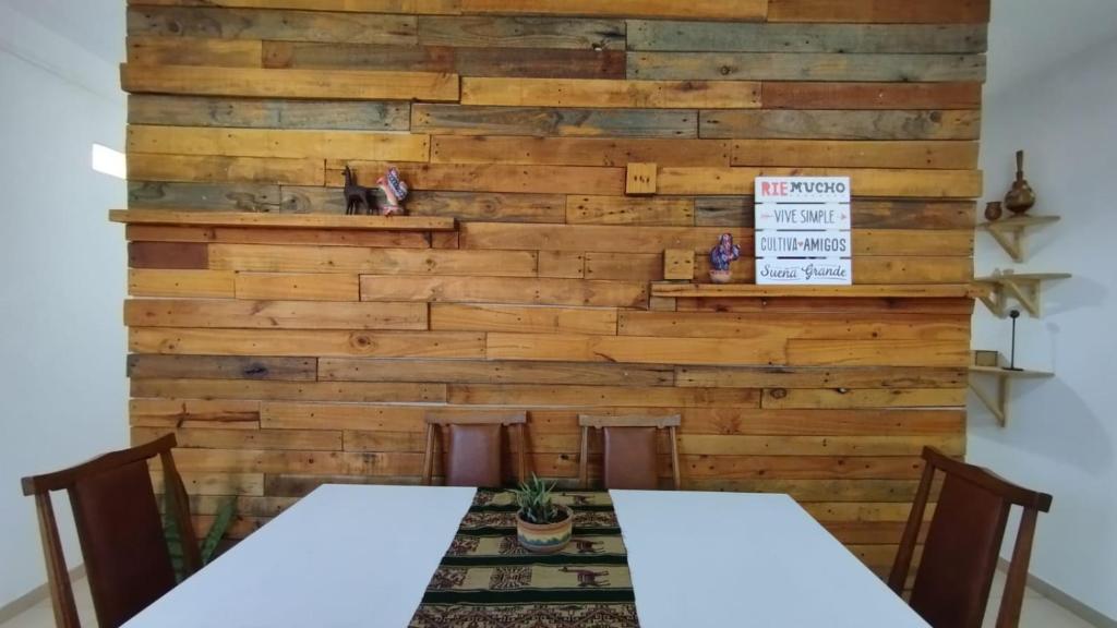a wall made from reclaimed wood with a table and chairs at Namiva lll in Cordoba