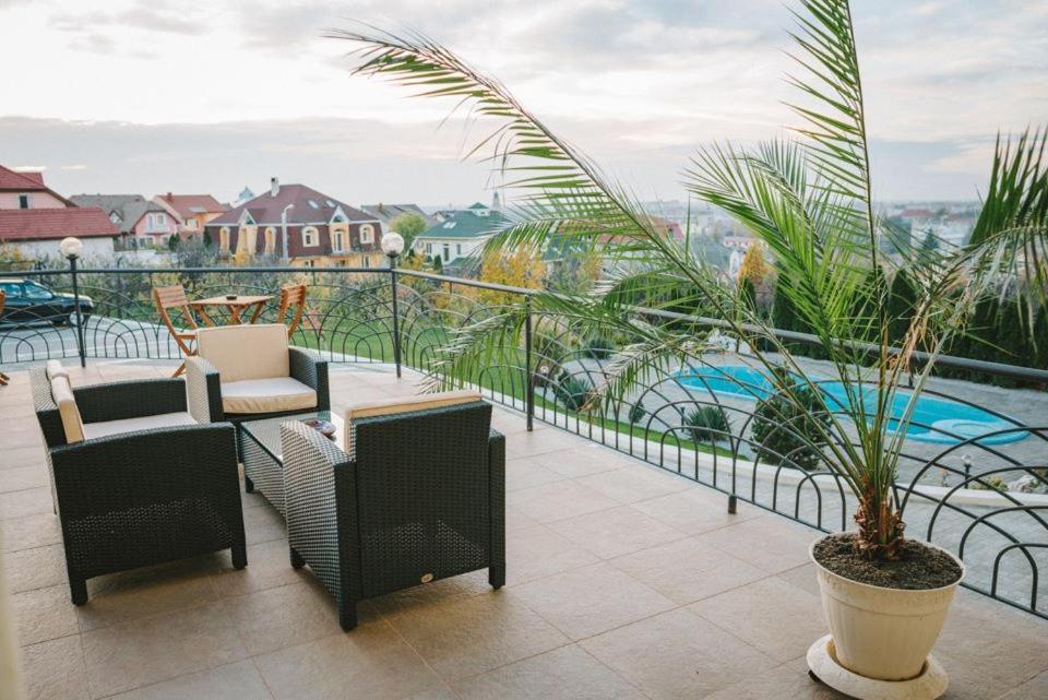 Un balcón con sillas y plantas y una piscina. en APARTHOTEL Panoramis Residence en Oradea