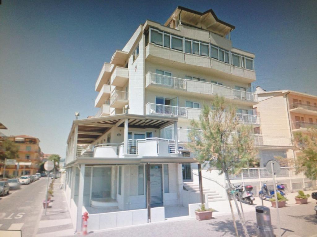 un edificio blanco alto al lado de una calle en Maison Belle Vue, en Chioggia