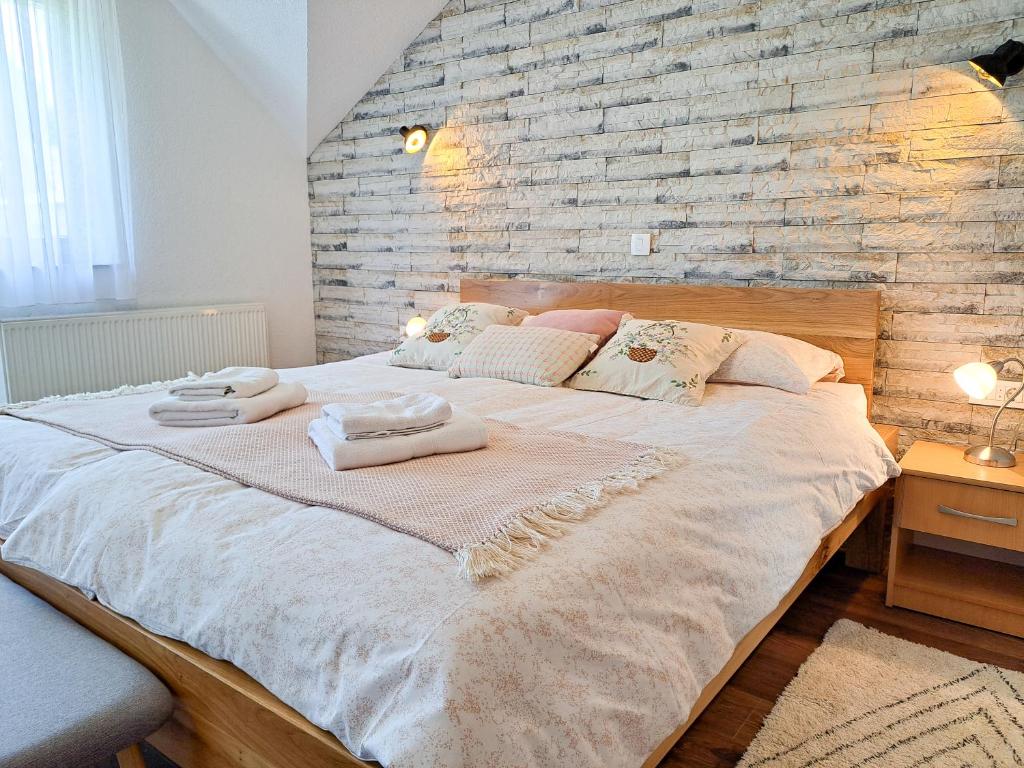 - un grand lit dans une chambre dotée d'un mur en briques dans l'établissement B&B Villa Plitvica, à Plitvica selo