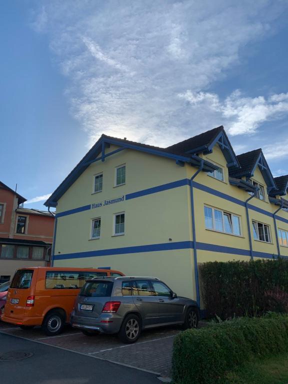 dom z dwoma samochodami zaparkowanymi przed nim w obiekcie Haus Jasmund Ferienwohnung 1 w mieście Binz