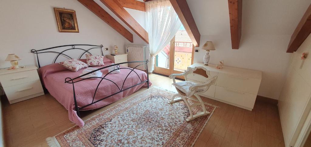 a bedroom with a bed and a chair and a window at Dei della Costiera 2 in Agerola