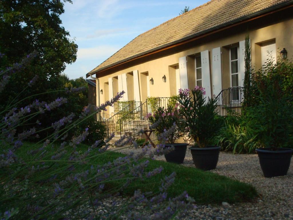 una casa con flores púrpuras delante de ella en Les Communs du Manoir, en Écully