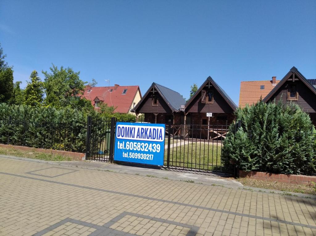 a sign on a fence in front of a house at Arkadia Domki in Dziwnów