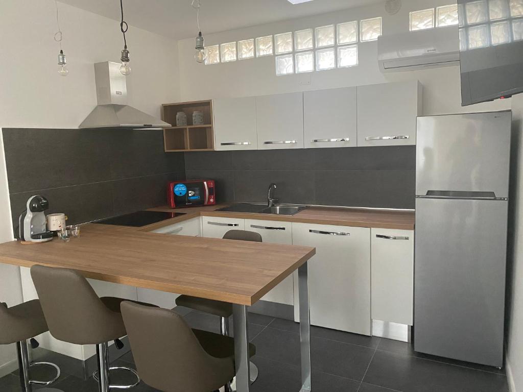 a kitchen with a wooden table and a refrigerator at AL MAR 38 in Brindisi