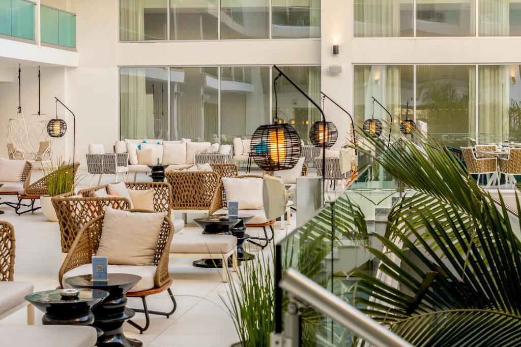 a lobby with chairs and tables in a building at NissiBlu Beach Resort in Ayia Napa