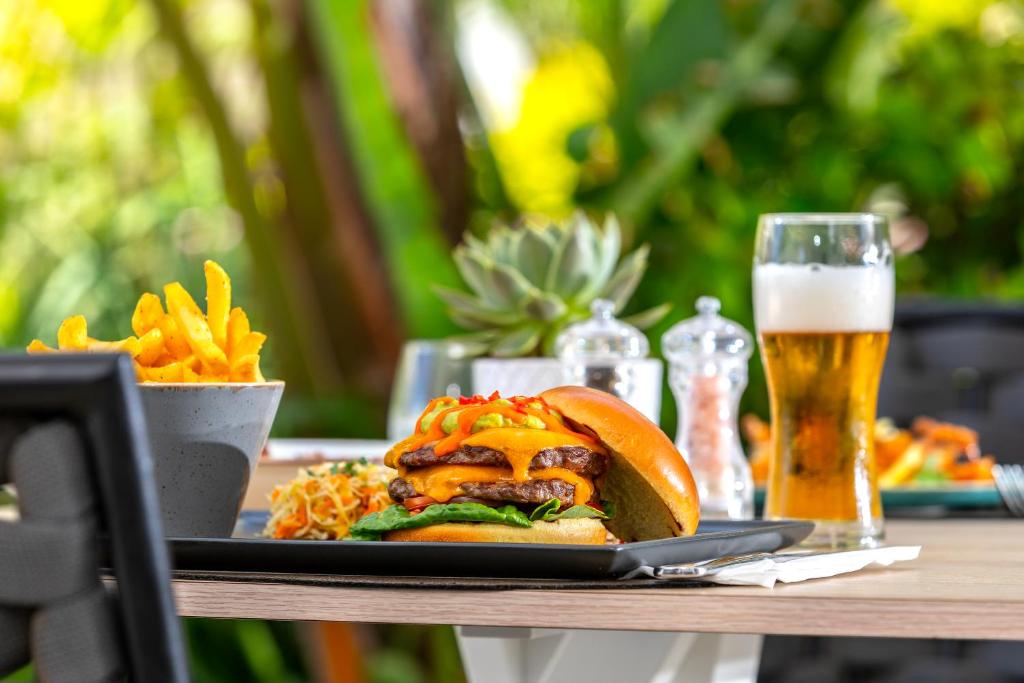 a table with a plate of food and a glass of beer at NissiBlu Beach Resort in Ayia Napa
