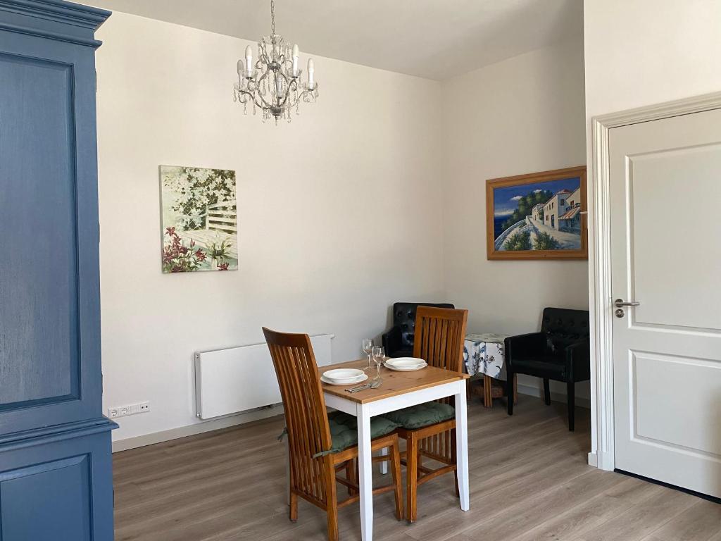 a dining room with a white table and chairs at Basic Little House Scheveningen in Scheveningen