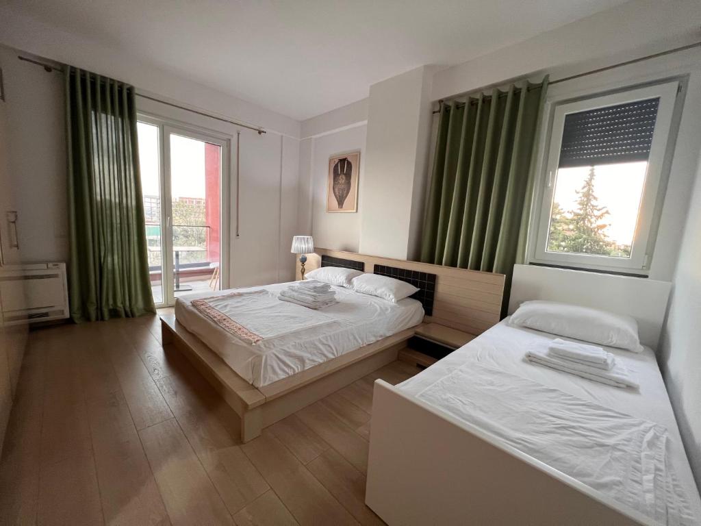 a bedroom with two beds and a window at Kino Apartment in Tirana