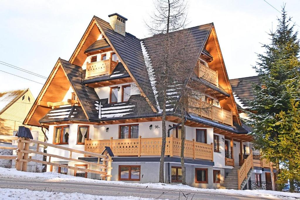 uma grande casa de madeira na neve em Willa Parzenica em Bukowina Tatrzańska