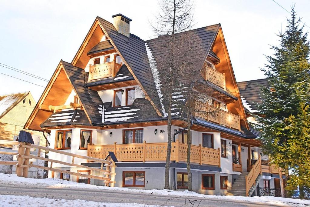 a large wooden house in the snow at Willa Parzenica in Bukowina Tatrzańska