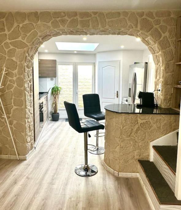 - une cuisine avec un comptoir et des chaises dans la chambre dans l'établissement Une belle maison avec 2 chambre, à Croix