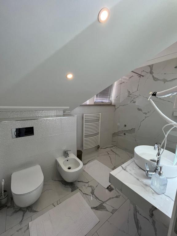 uma casa de banho branca com um WC e um lavatório em Villa Luca em Sarajevo