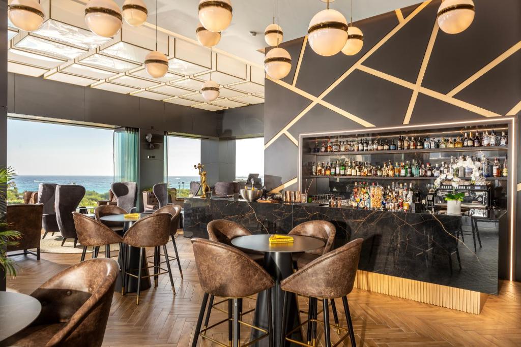 a bar with chairs and tables in a restaurant at NissiBlu Beach Resort in Ayia Napa