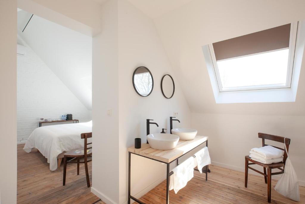 a white bedroom with a sink and a bed at Le Charbonnage in Genk