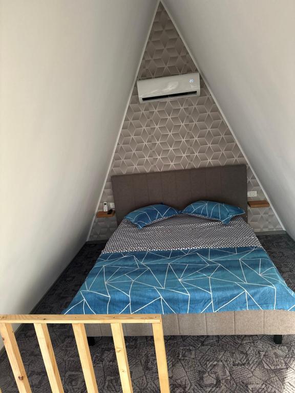 ein Schlafzimmer mit einem Bett im Dachgeschoss in der Unterkunft Casa de lemn 2,Tip A in Corbu