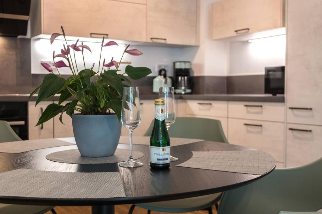 a table with a bottle of wine and a glass at CityHome Christopher CHC in Kulmbach