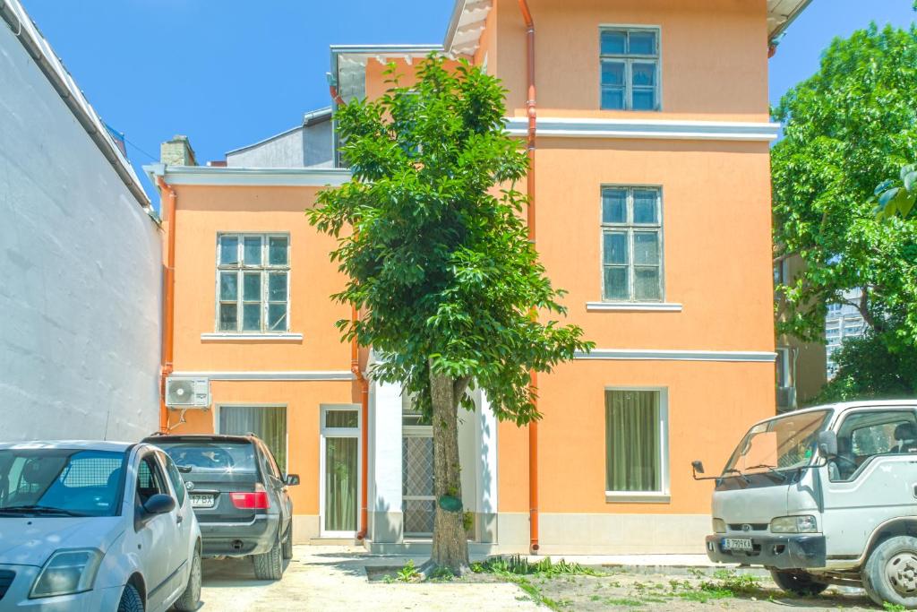 a orange building with cars parked in front of it at Filaret studios with free parking in Varna City