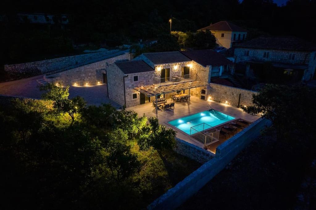 einen Ausblick über ein Haus mit Pool in der Nacht in der Unterkunft Villa Marlea Konavle Dubrovnik in Gruda