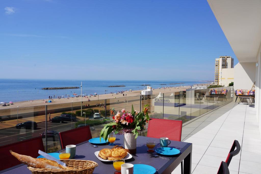 un tavolo con cibo e vista sulla spiaggia di sur la plage ! a Valras-Plage