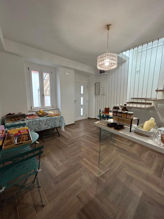 um quarto amplo com pisos em madeira e um lustre em B&B Dimora Santucci em Rodi Garganico