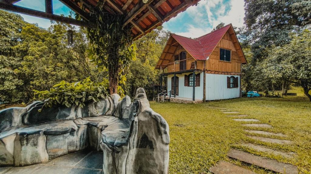 une maison avec une statue devant une maison dans l'établissement Rancho Hanna - Pousada, Camping e Comidaria, à Iporanga