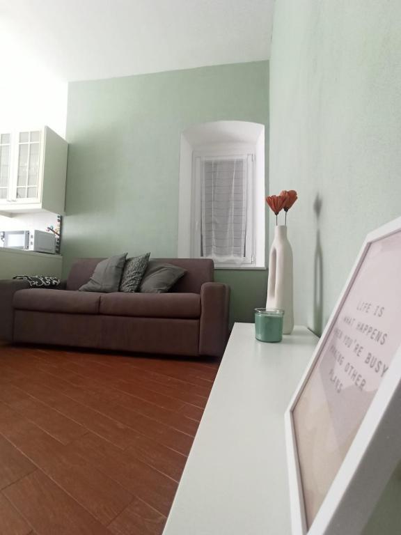 a living room with a couch and a vase of flowers at speZialhouse - Centro Storico & Cinque Terre in La Spezia