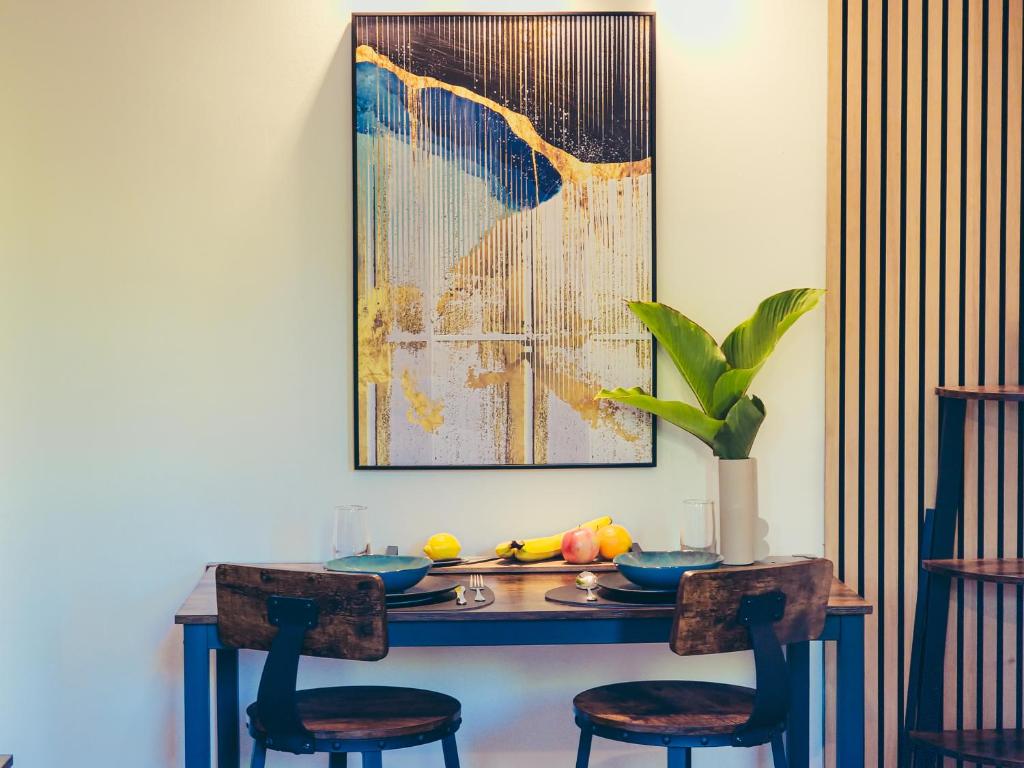 einem Esstisch mit 2 Stühlen und einem Gemälde in der Unterkunft Residence ǁ Corino in Biograd na Moru