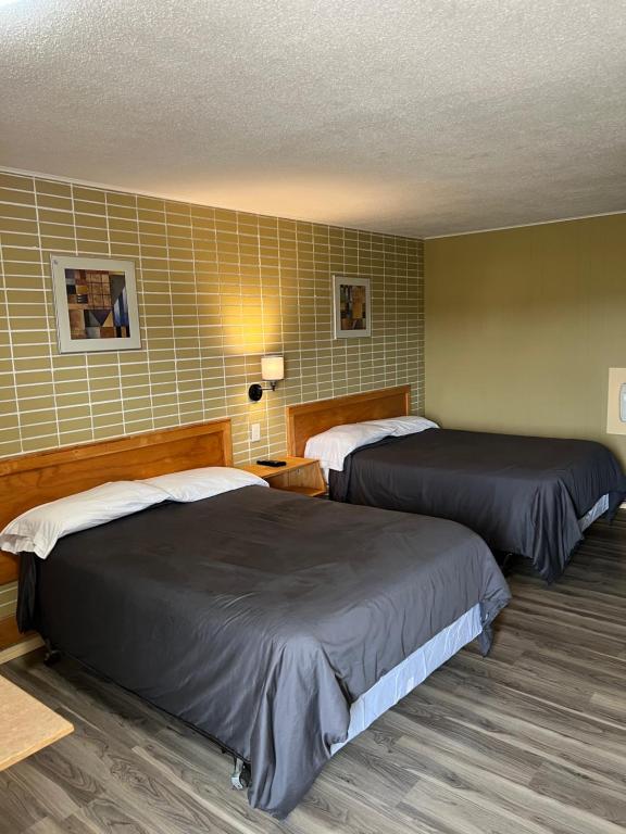 a hotel room with two beds in a room at Motel 66 in Transcona