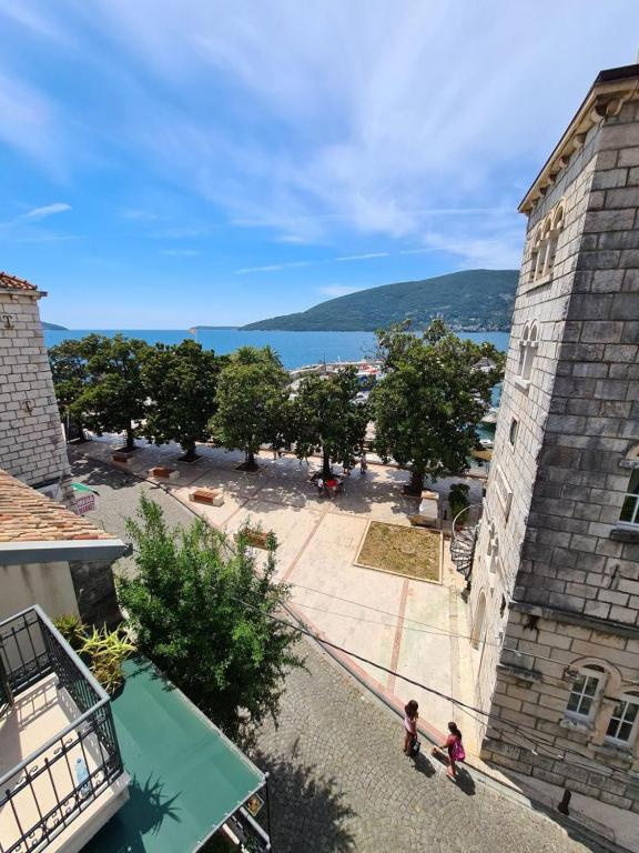 two people standing in a courtyard of a building at Skver Studio Apartments in Herceg-Novi