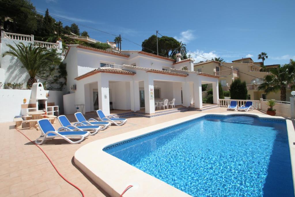 uma villa com piscina em frente a uma casa em Sesam - sea view villa with private pool in Moraira em Moraira