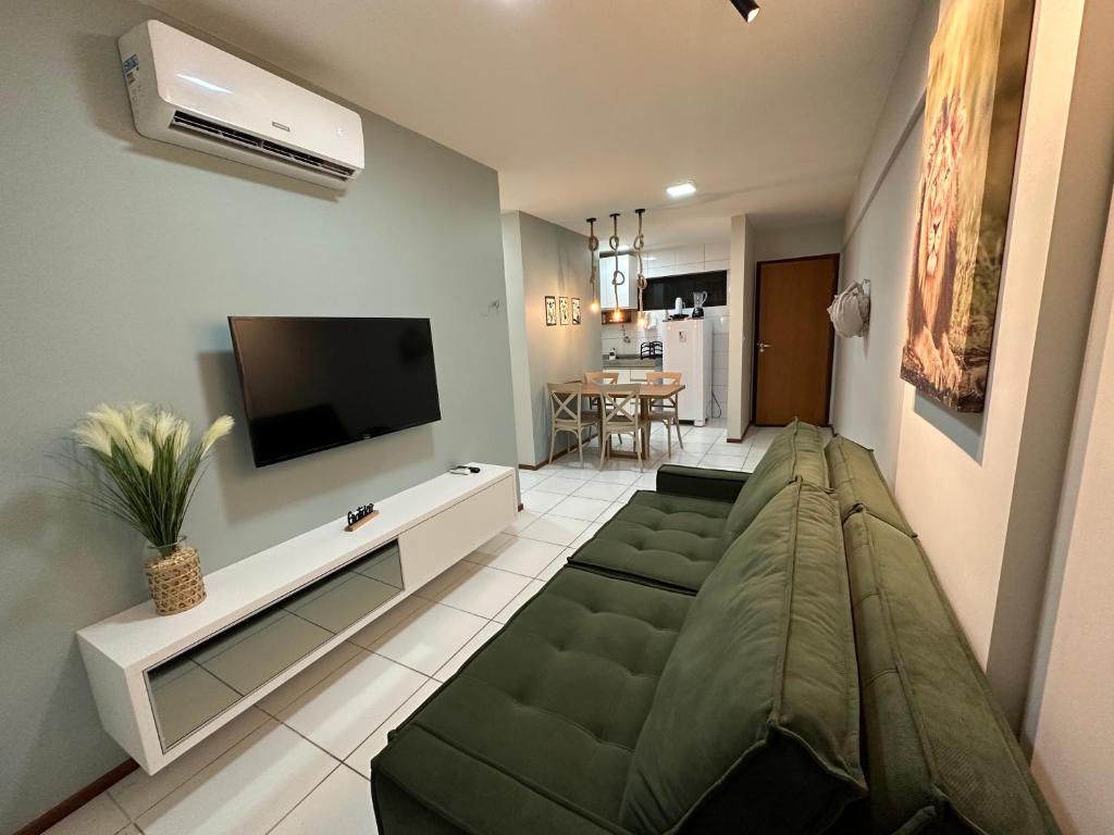 uma sala de estar com um sofá e uma televisão de ecrã plano em 02 QUARTOS, a 200 metros da PRAIA de PAJUÇARA em Maceió