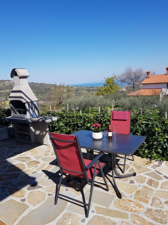 eine Terrasse mit einem Tisch, Stühlen und einem Grill in der Unterkunft Apartment and rooms Parus in Koper