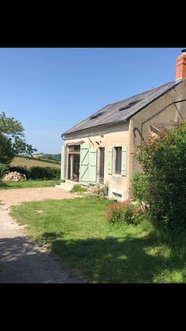 a house with a grass yard next to a building at Les Chaumes en Morvan in Préporché
