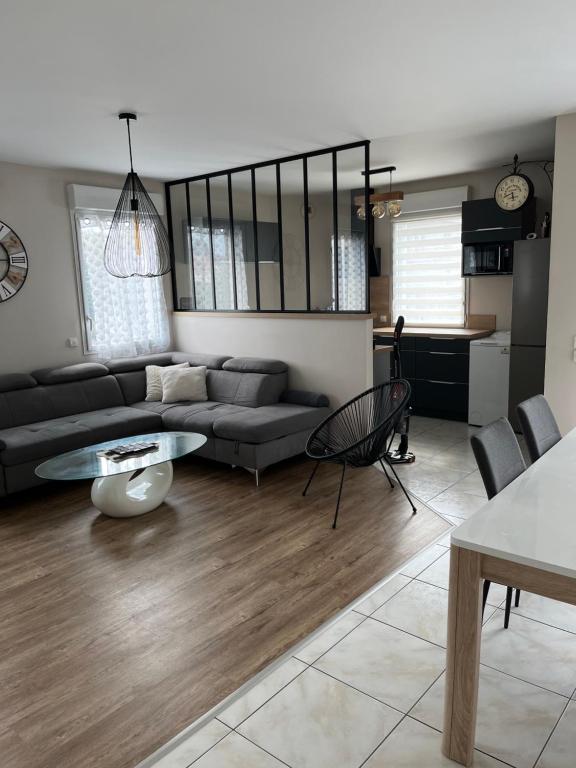 un salon avec un canapé et une table dans l'établissement Charmant appartement la Roche sur Yon, à La Roche-sur-Yon