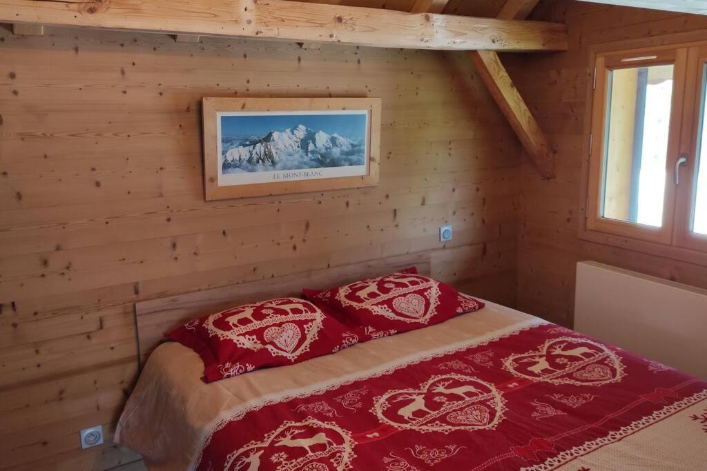 1 dormitorio con 1 cama en una cabaña de madera en L'échappée Belle en Montagne, en Mieussy