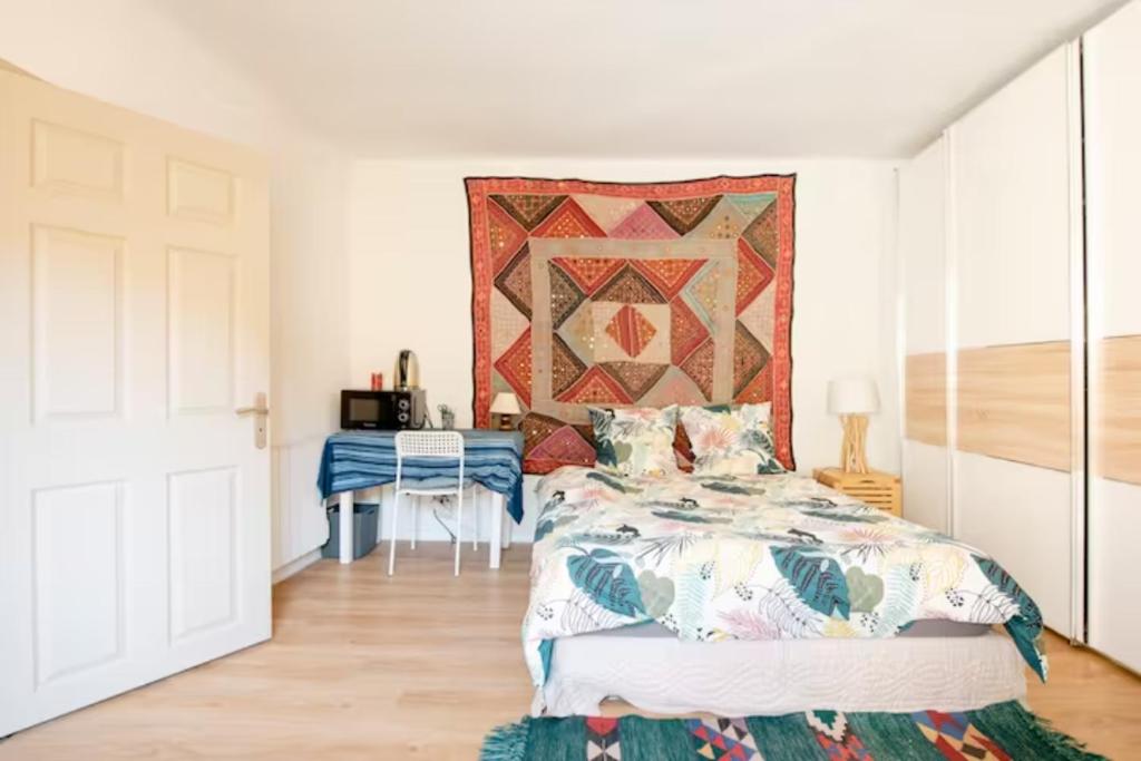 - une chambre avec un lit et une couette murale dans l'établissement Aude en Provence, à Meyrargues