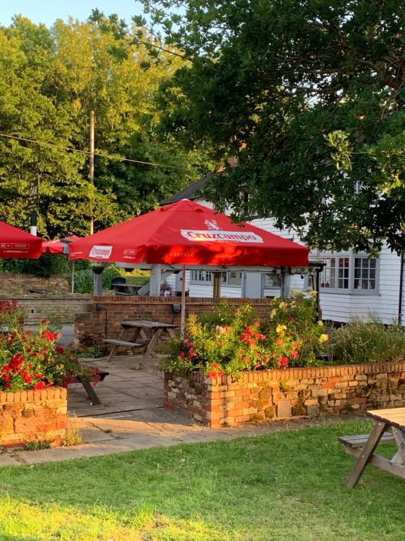 a restaurant with a red umbrella and tables and flowers at The Great Escape - Pet Friendly - Pets stay FREE in Rye