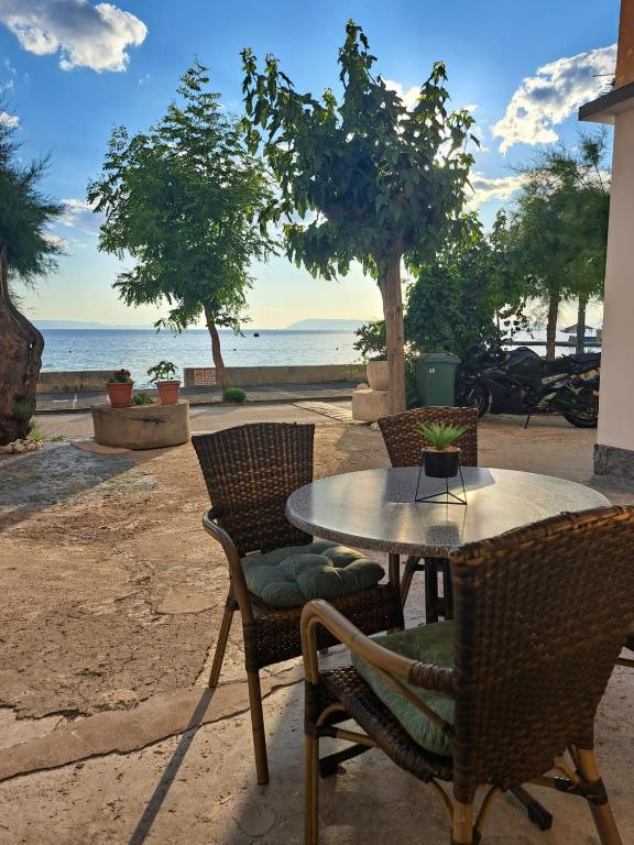 a patio with a table and chairs and the ocean at Apartmani Ante 1 in Drašnice