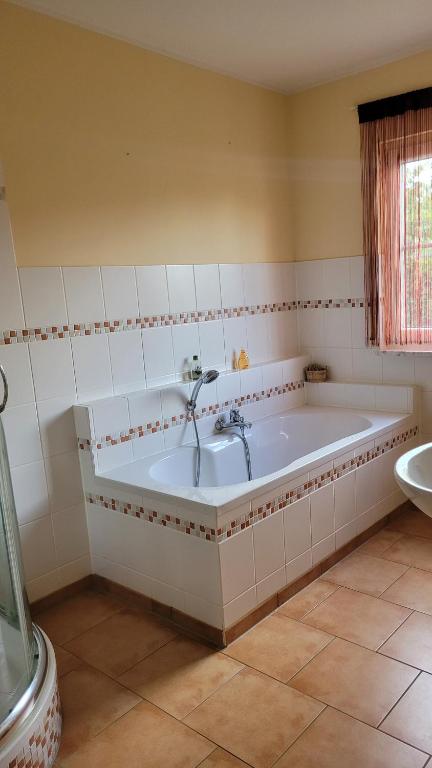 a large white tub in a bathroom with a sink at Traudis Ferienwohnung in Brunow