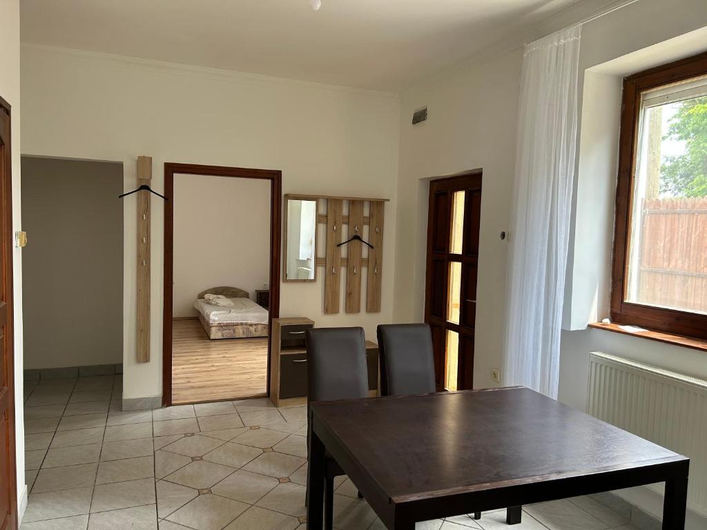 ein Esszimmer mit einem Tisch und Stühlen sowie ein Schlafzimmer in der Unterkunft M35 4s Debrecen Apartman in Debrecen