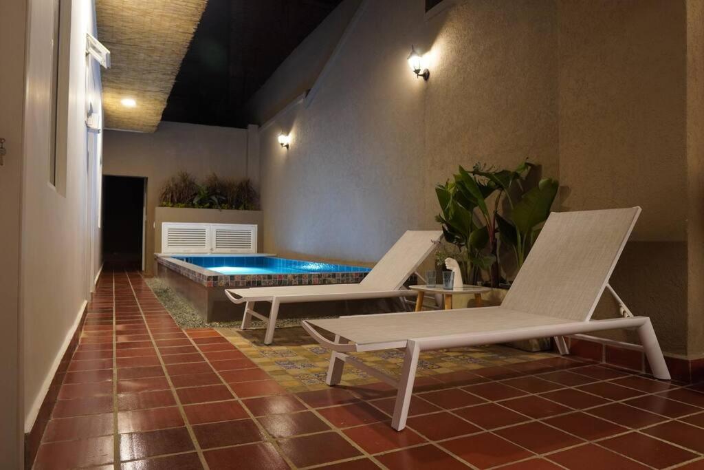 un patio avec deux chaises et une piscine dans l'établissement Nueva en San Antonio Cali, La casa de Toña, à Cali