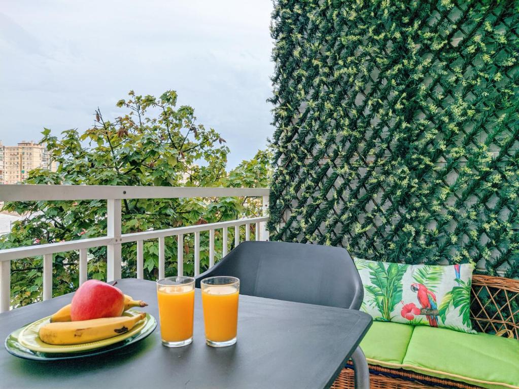 einen Tisch mit einem Obstteller und zwei Gläsern Orangensaft in der Unterkunft Chambre de Molina in Málaga