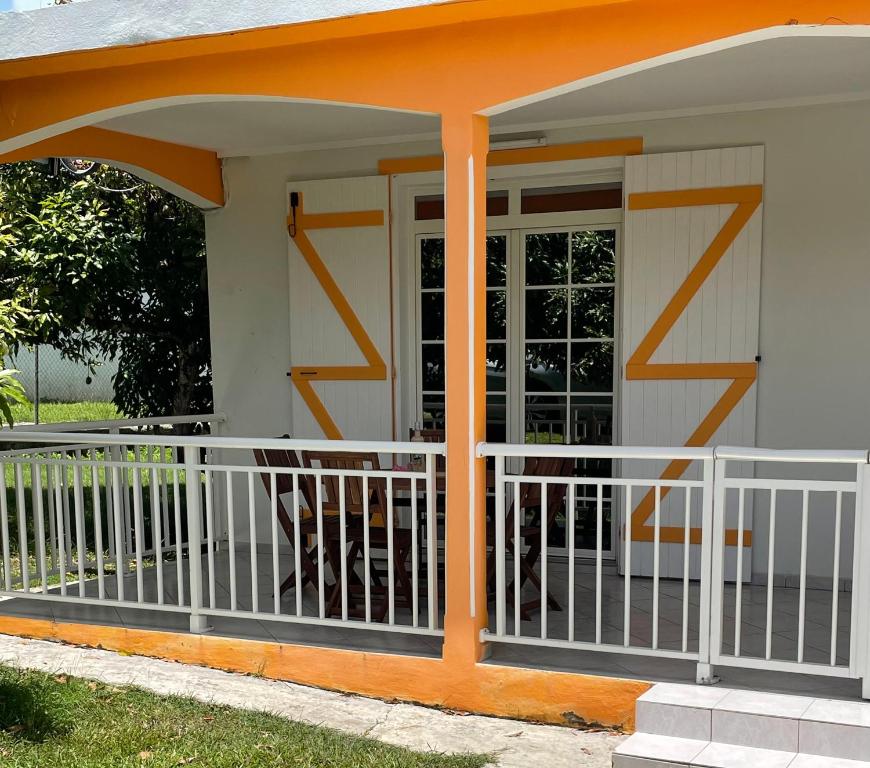 an orange and white porch with a white railing at La Maisoncelle in Petit-Canal
