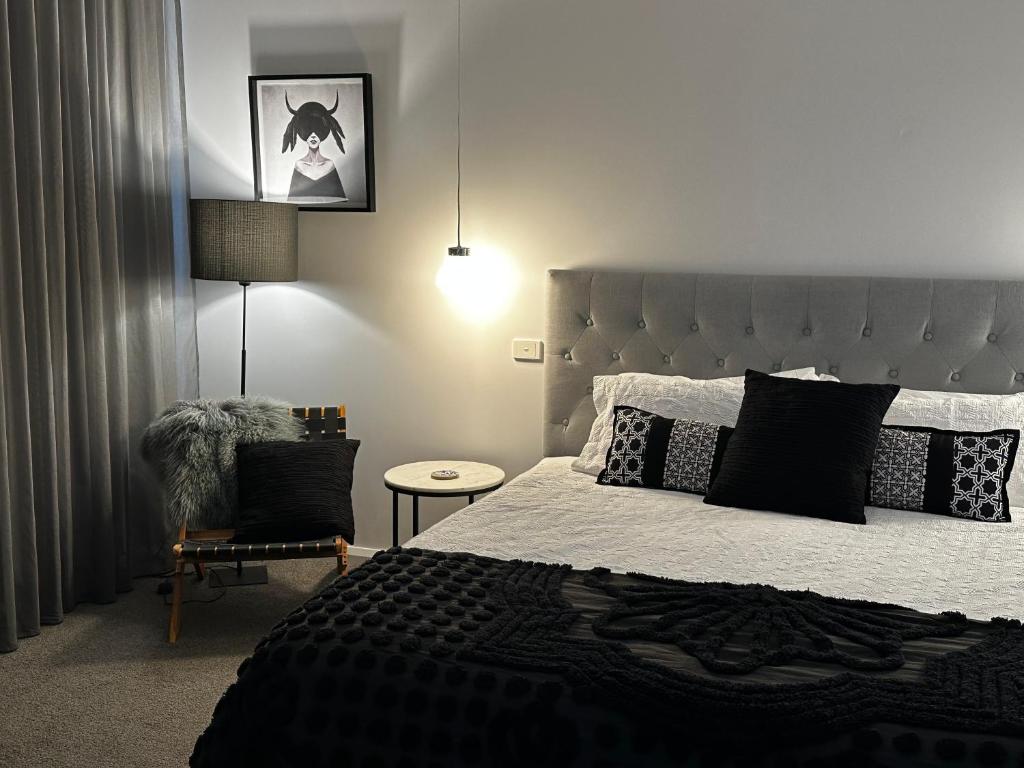 una camera da letto con un letto grande e una sedia di Tranquilo Daylesford a Daylesford