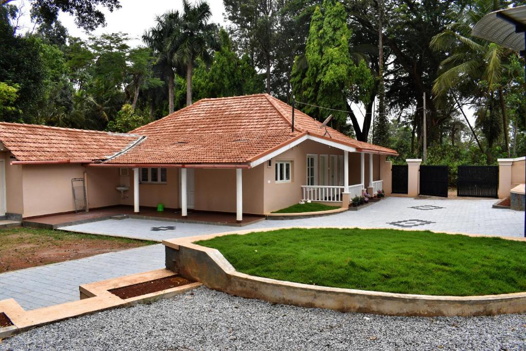 una pequeña casa con un patio de hierba delante de ella en Rochas Valley Homestay, en Suntikoppa